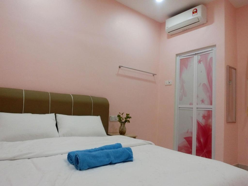 太平Taiping Cozy Homestay II的一间卧室配有一张带蓝色毛巾的床