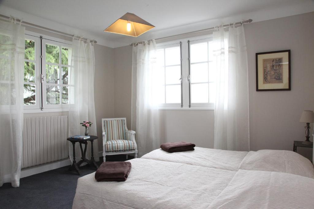 圣让皮耶德波尔Gure Lana的一间卧室设有两张床、一把椅子和窗户。