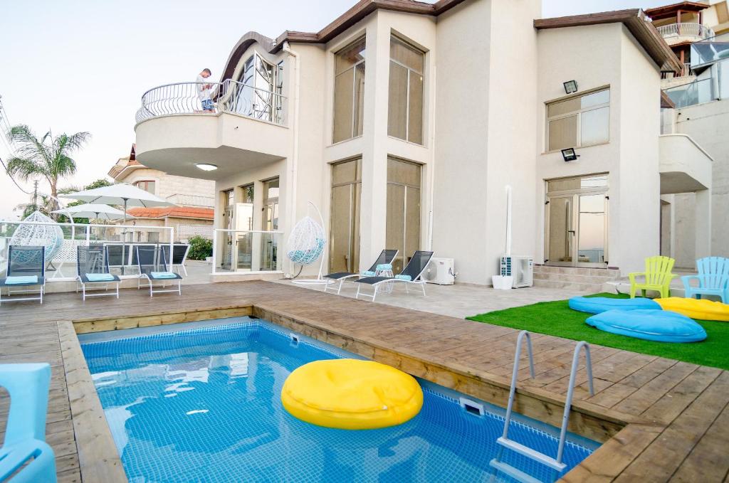 提比里亚Blue Sky Villa view的一座房子,设有一个游泳池,上面有黄薯