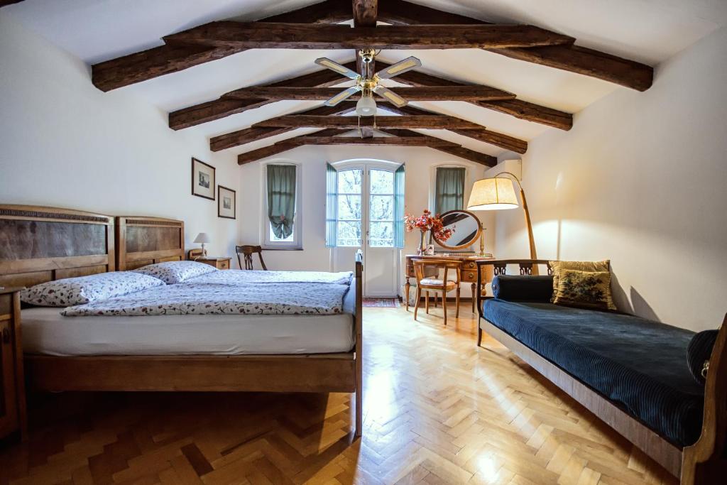 的里雅斯特法伍斯塔别墅住宿加早餐旅馆的一间卧室设有两张床和横梁天花板。