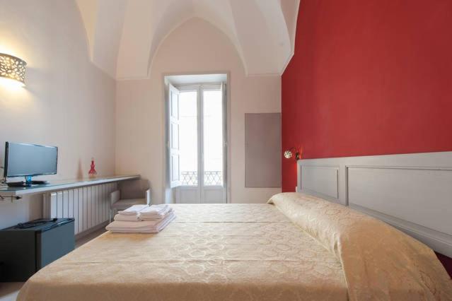 加拉蒂纳Kaleidos Guest House的一间卧室设有一张红色墙壁的大床