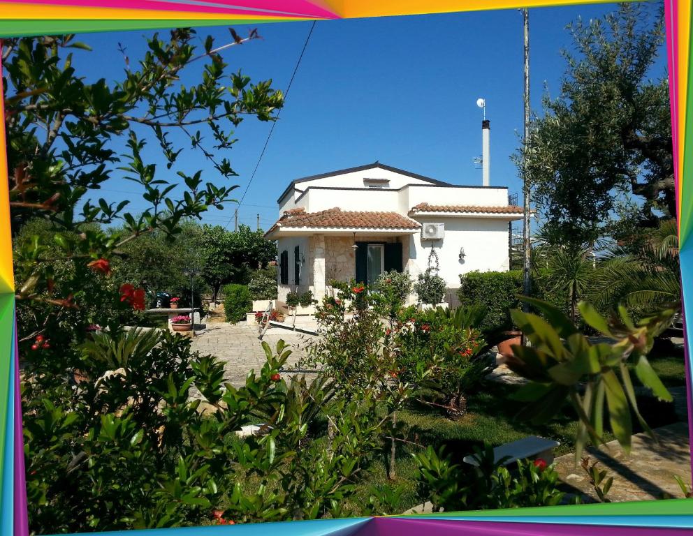 孔韦尔萨诺Villa Maria的一座种植了植物的院子中的白色房子