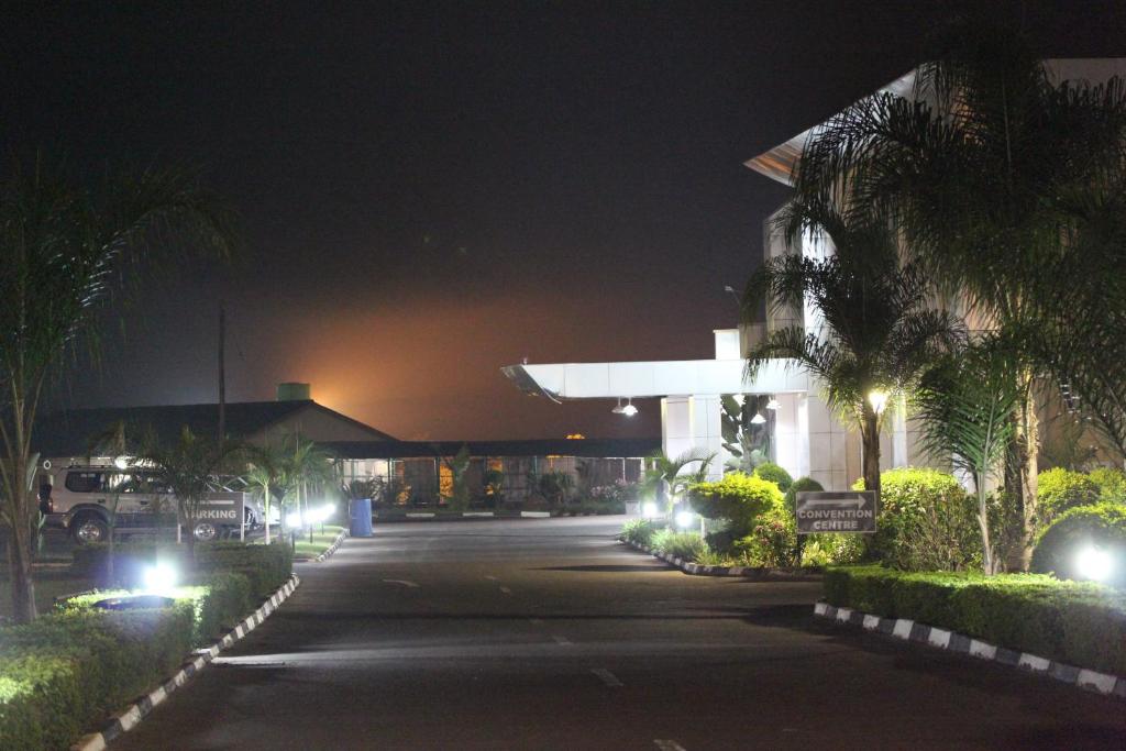 Kitwe莫巴酒店及会议中心的一条空的街道,晚上有楼房和棕榈树