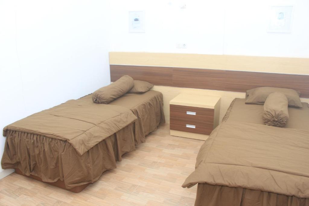 沃诺索博Aurora Guest House的一间卧室设有两张床,铺有木地板