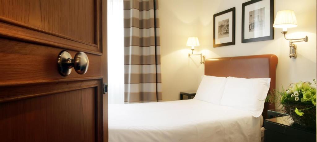 罗马圣奇阿拉酒店的一间卧室配有一张带木制床头板的床