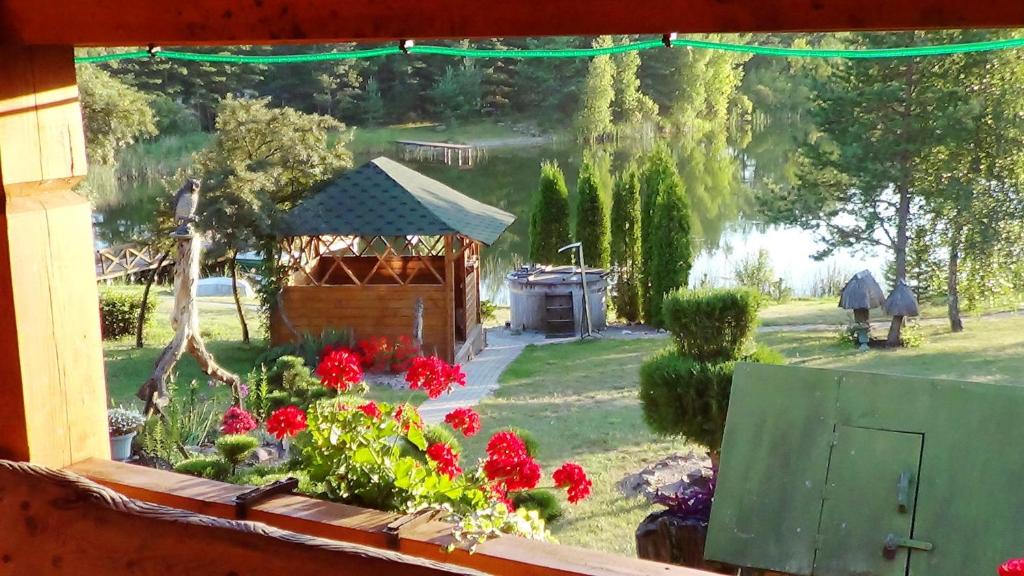 RuišėnaiSodyba "Sakalų slėnis"的鲜花花园美景窗户和凉亭