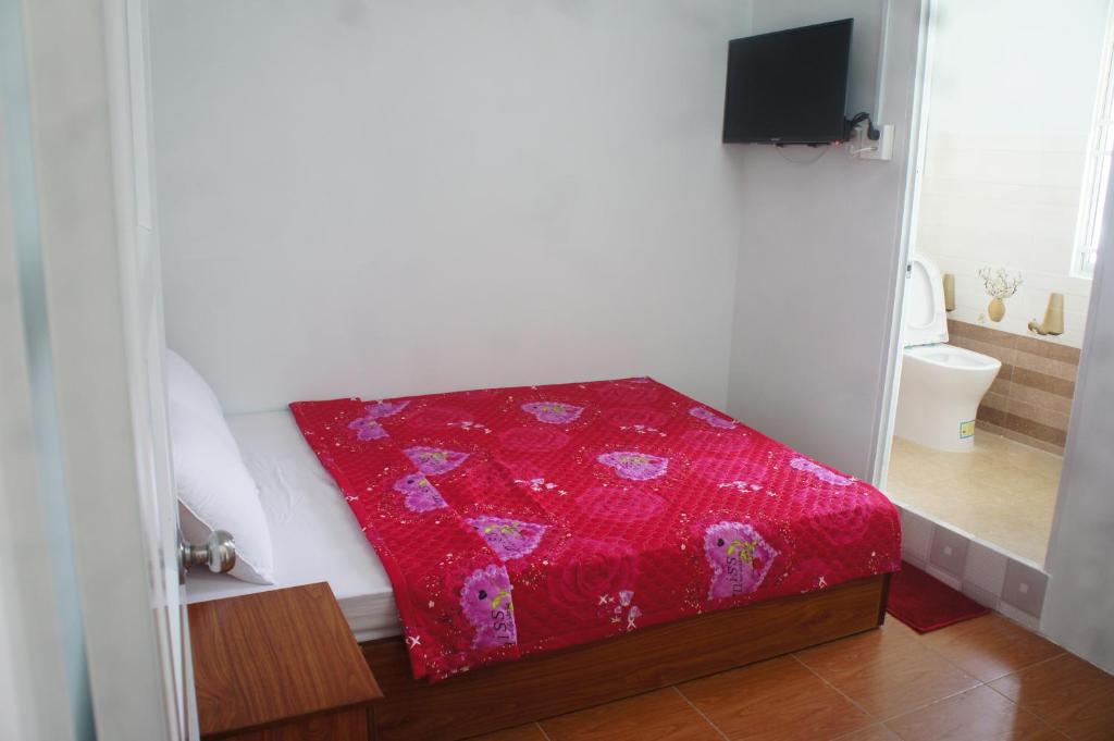 芹苴BangBang Motel的一张红毯,坐在房间里的床边