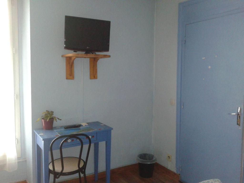 艾克斯莱班安纳波利斯酒店的一间设有蓝色桌子的房间和墙上的电视