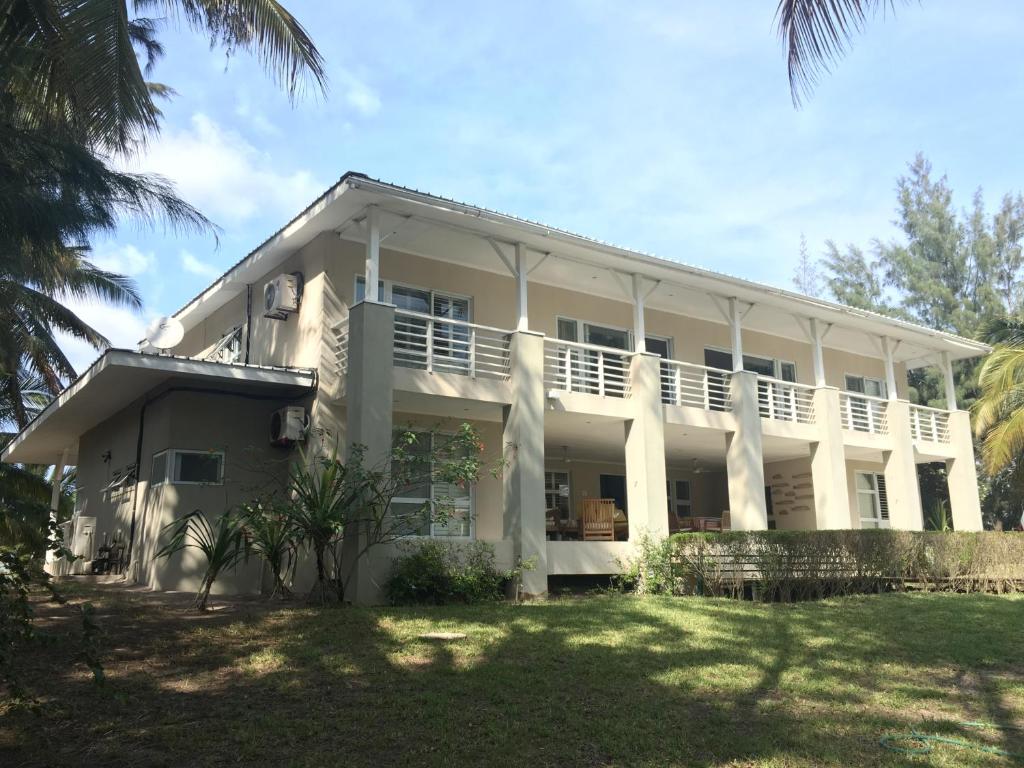 伊尼扬巴内Barra Beach Villa的一座白色的大建筑,前面有棕榈树