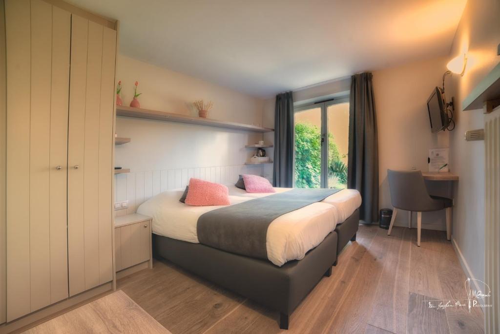 德哈恩比德尔迪克酒店的一间卧室配有带粉红色枕头的床。