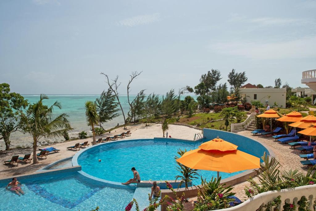 吉汶瓦Moja Tuu The Luxury villas & Nature Retreat的一个带遮阳伞的游泳池和海滩