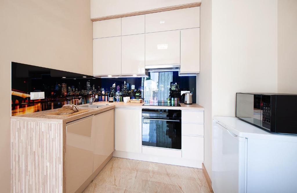 华沙Awangarda Home Apartment的厨房配有白色橱柜和微波炉