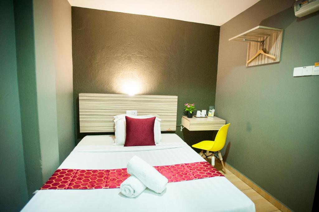 瓜拉丁加奴DJ CITI INN HOTEL的小房间设有两张床和一张黄色椅子