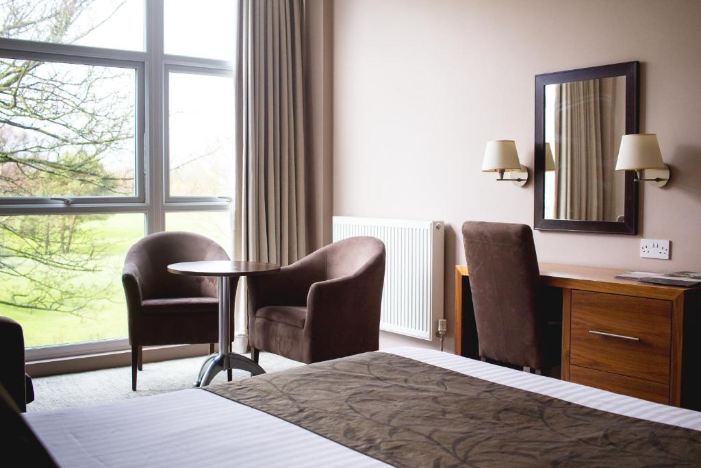 格里姆斯比Humber Royal Hotel的酒店客房,配有一张床、一张桌子和椅子