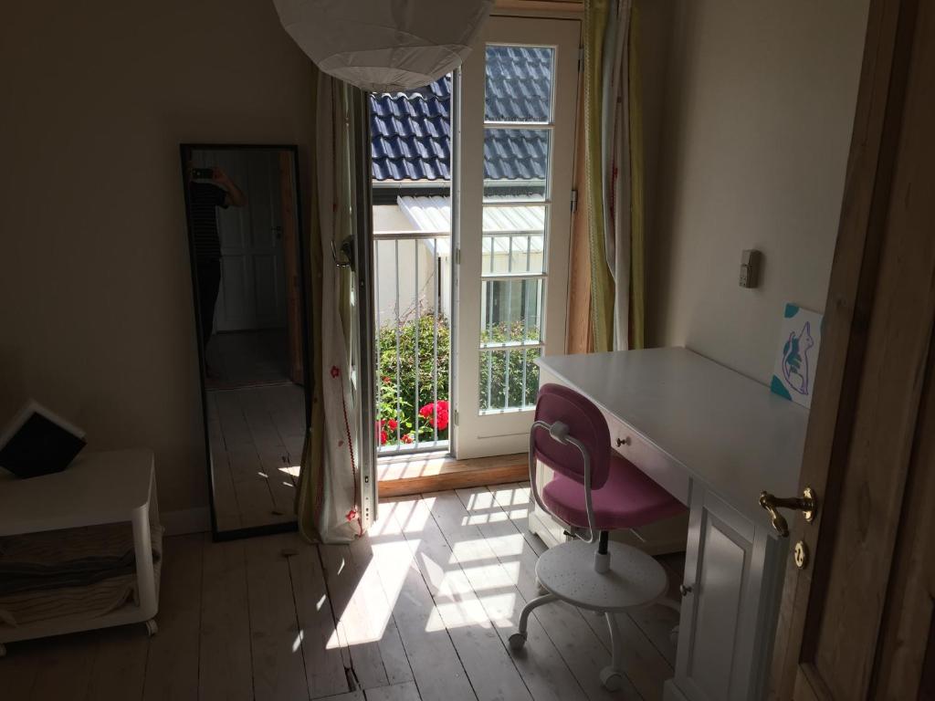 哥本哈根Villa Valby的一间带书桌和粉红色椅子的浴室