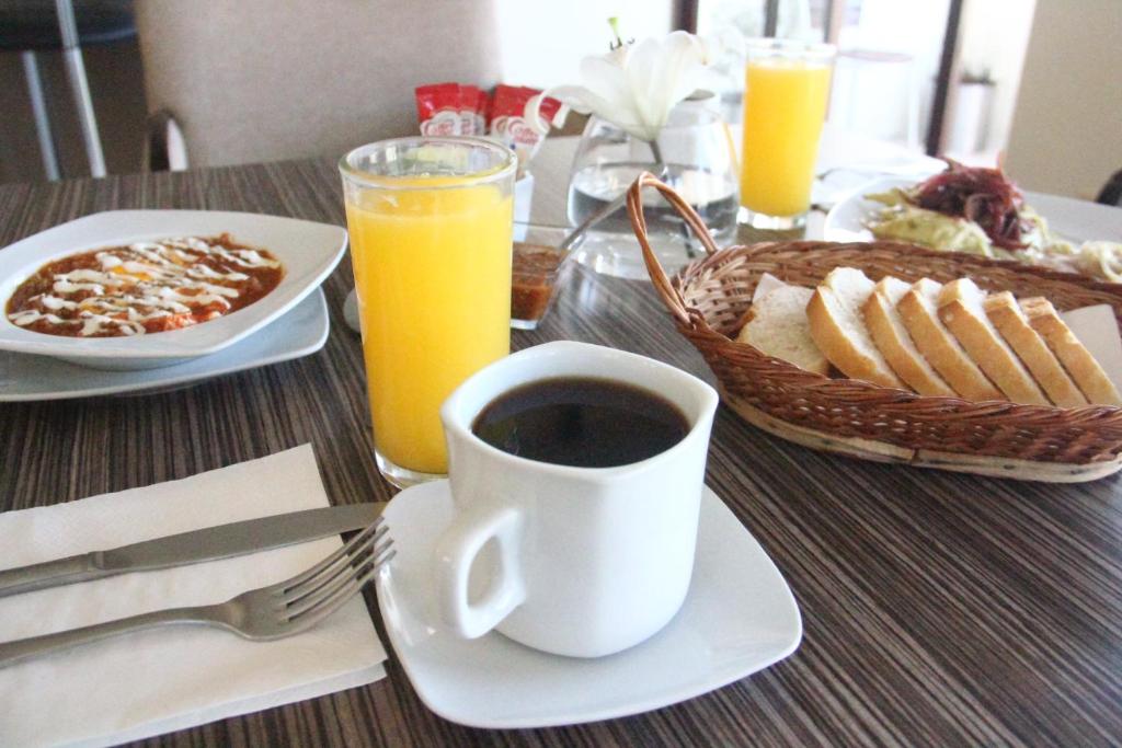 萨卡特卡斯卡萨托雷斯酒店的一张桌子,上面放着一杯咖啡和一篮子的食物