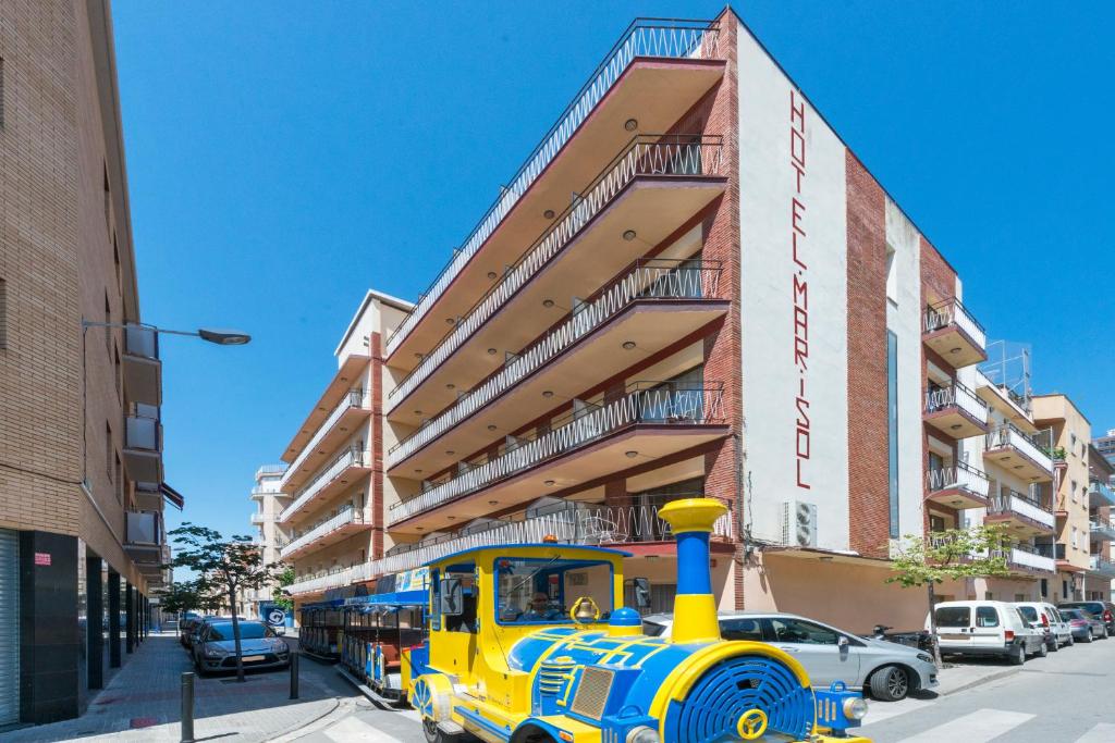 卡里拉Hotel Mar i Sol的停在大楼前的黄色和蓝色火车