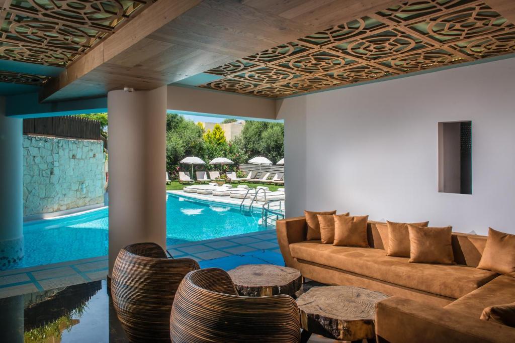 赫索尼索斯Anesis Blue Boutique Hotel的带沙发和椅子的客厅以及游泳池。