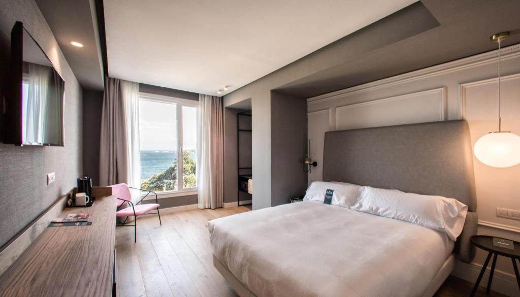 拉科鲁尼亚里亚索尔酒店的一间卧室设有一张大床和一个大窗户