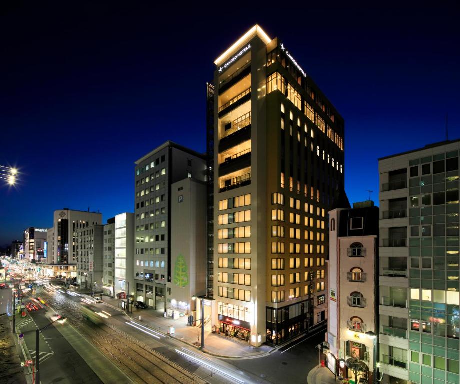 广岛广岛八丁堀光辉酒店的夜幕降临的城市街道上一座高楼