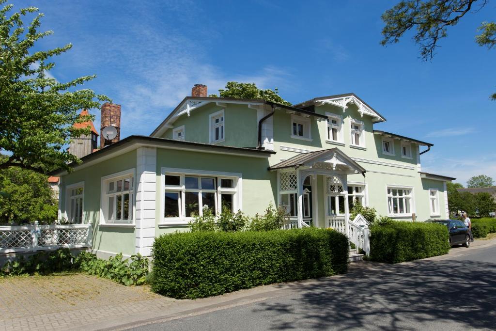 米德尔哈根Haus Rosengarten的绿色和白色的大房子,带围栏