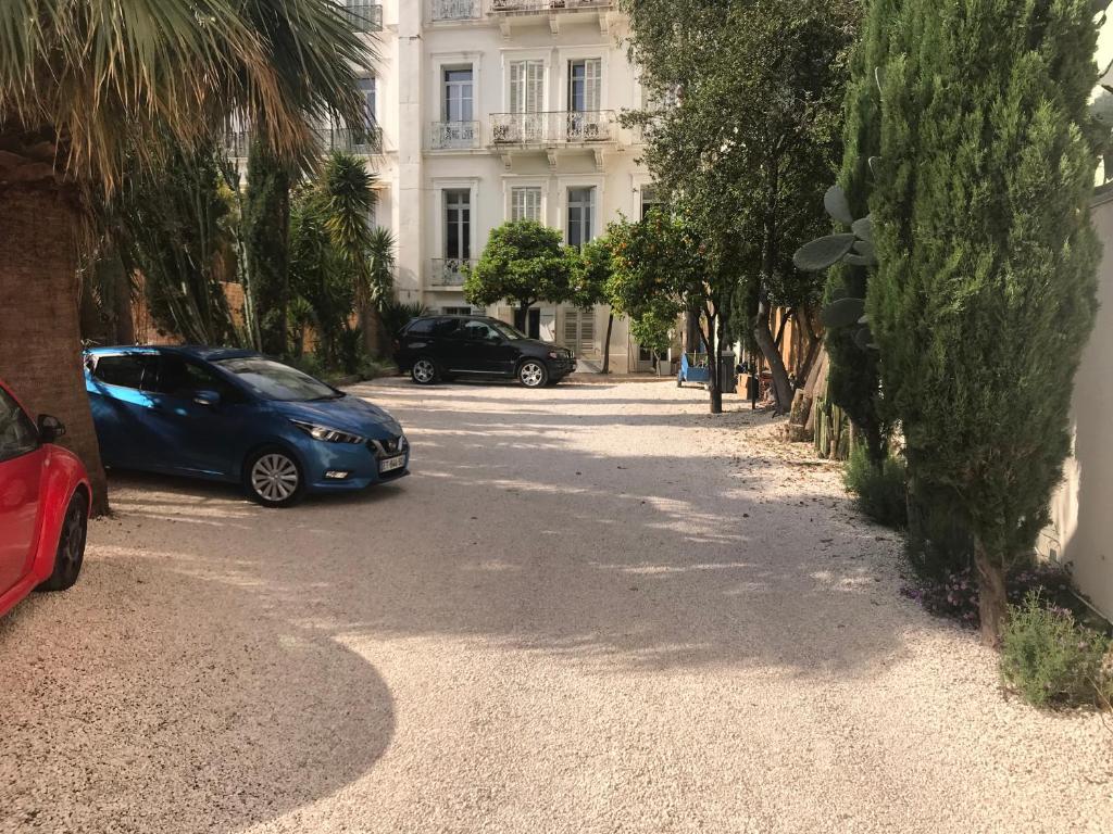 耶尔Aux Iles d'Or的两辆汽车停在大楼前的街道上