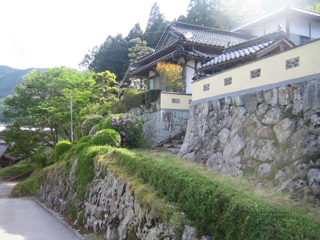 NiimiJapanese Style Inn Dohzen Miwa的房屋旁的石墙