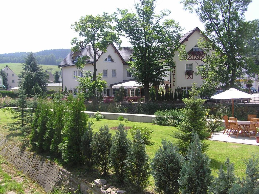 Pockau博尔格施洛申酒店的一座白色的大房子,有树木的院子
