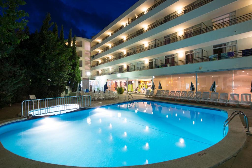 滨海托萨梅德普拉亚埃斯梅拉达公寓式酒店的晚上在酒店前面的一个大型游泳池