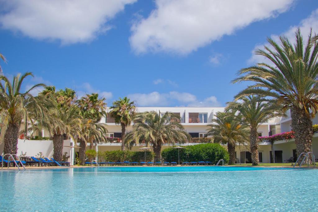 圣玛丽亚萨尔杜纳斯酒店的享有棕榈树度假村和游泳池的景色