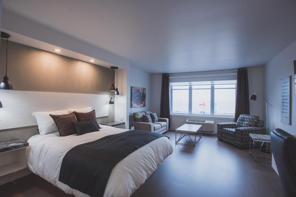 Ville-MarieLes suites de la chocolaterie的一间卧室设有一张大床和一个大窗户