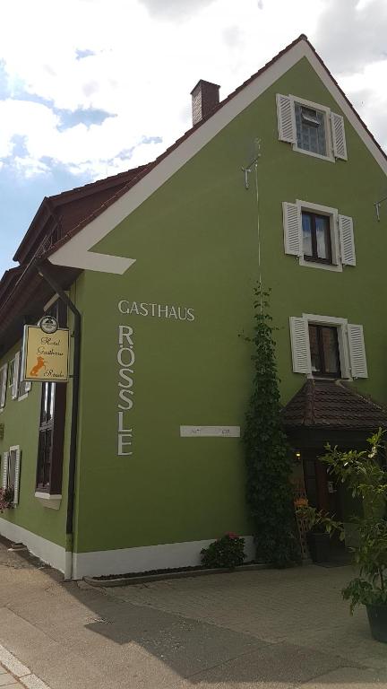 弗莱堡Hotel Gasthaus Rössle的绿色建筑的侧面有标志