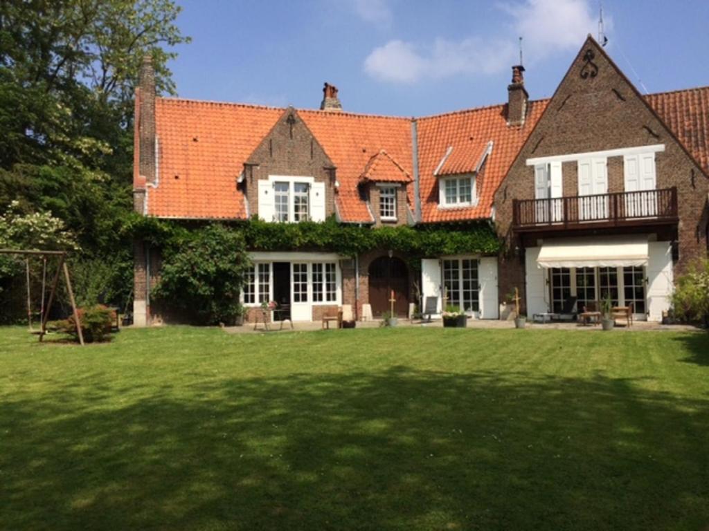CroixLe Pigeonnier, maison d'hôtes et Spa的一座大房子,带绿草庭院