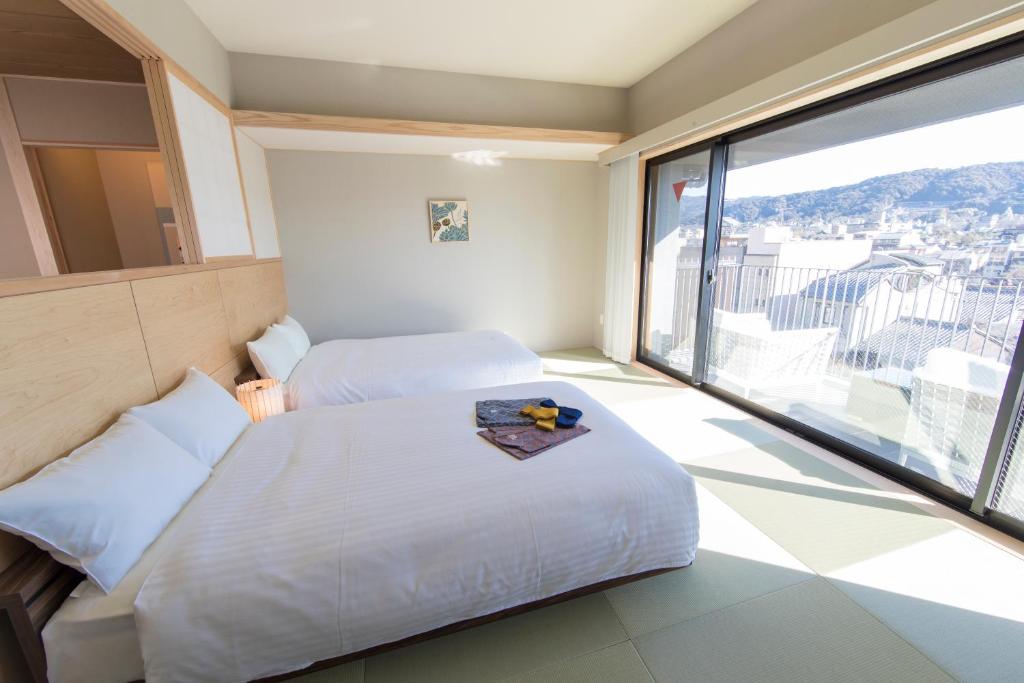 京都麦K之家酒店的酒店客房设有两张床和大窗户。