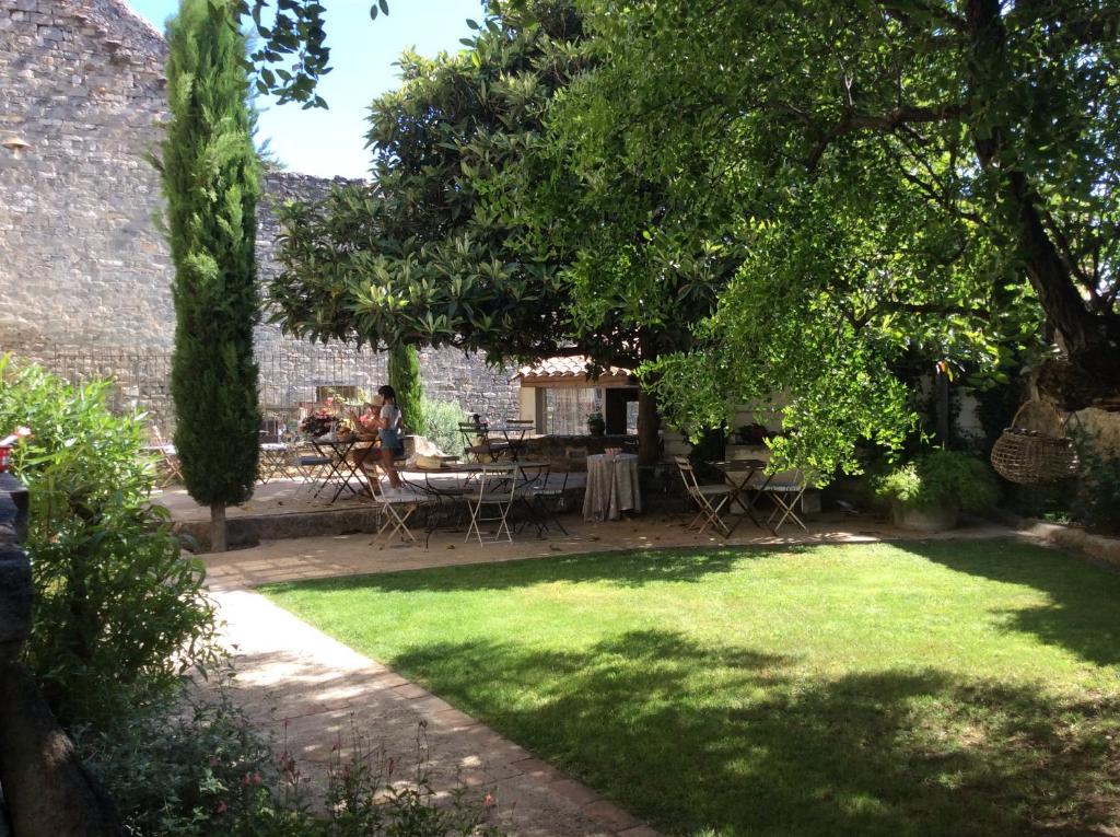 Caumont-sur-DuranceLe Posterlon的花园配有桌椅和树木