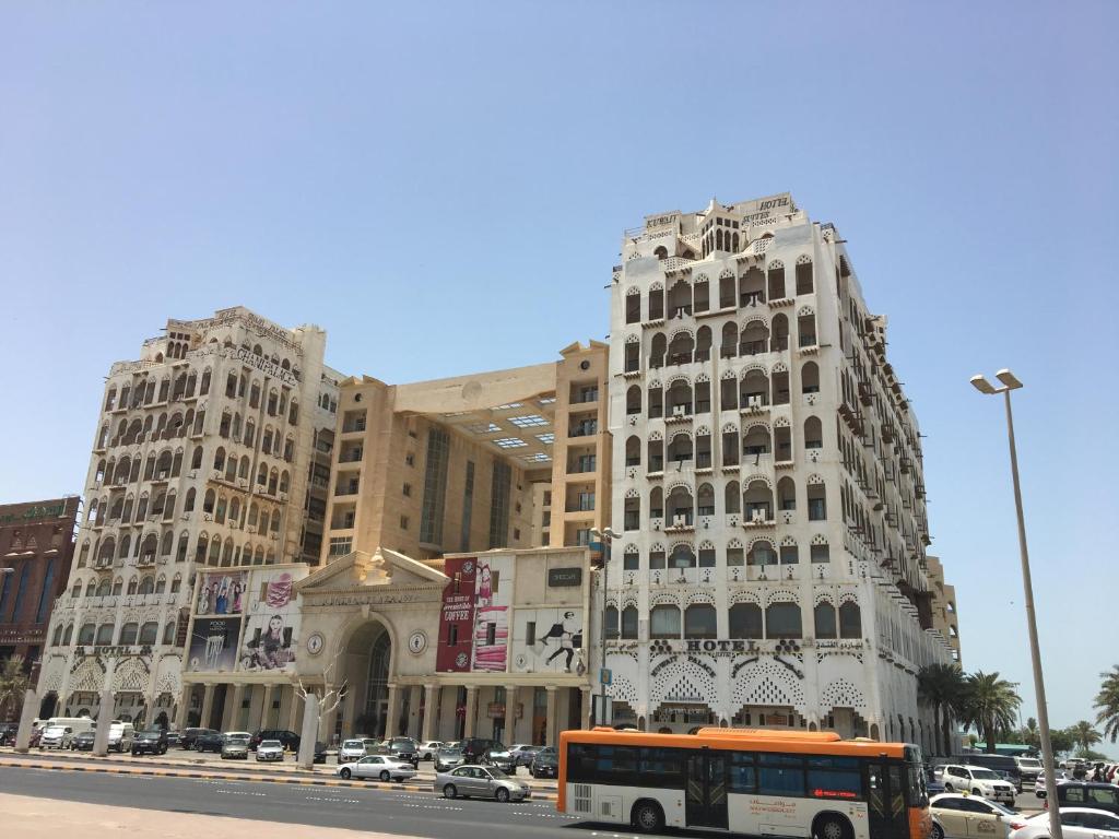 科威特Kuwait Palace Hotel的停在大楼前的橙色巴士