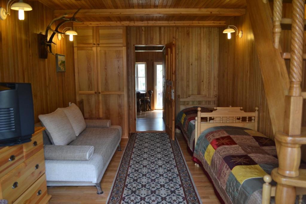 奈达Kotedžas prie pušelių的客房设有两张床、一张沙发和一台电视。