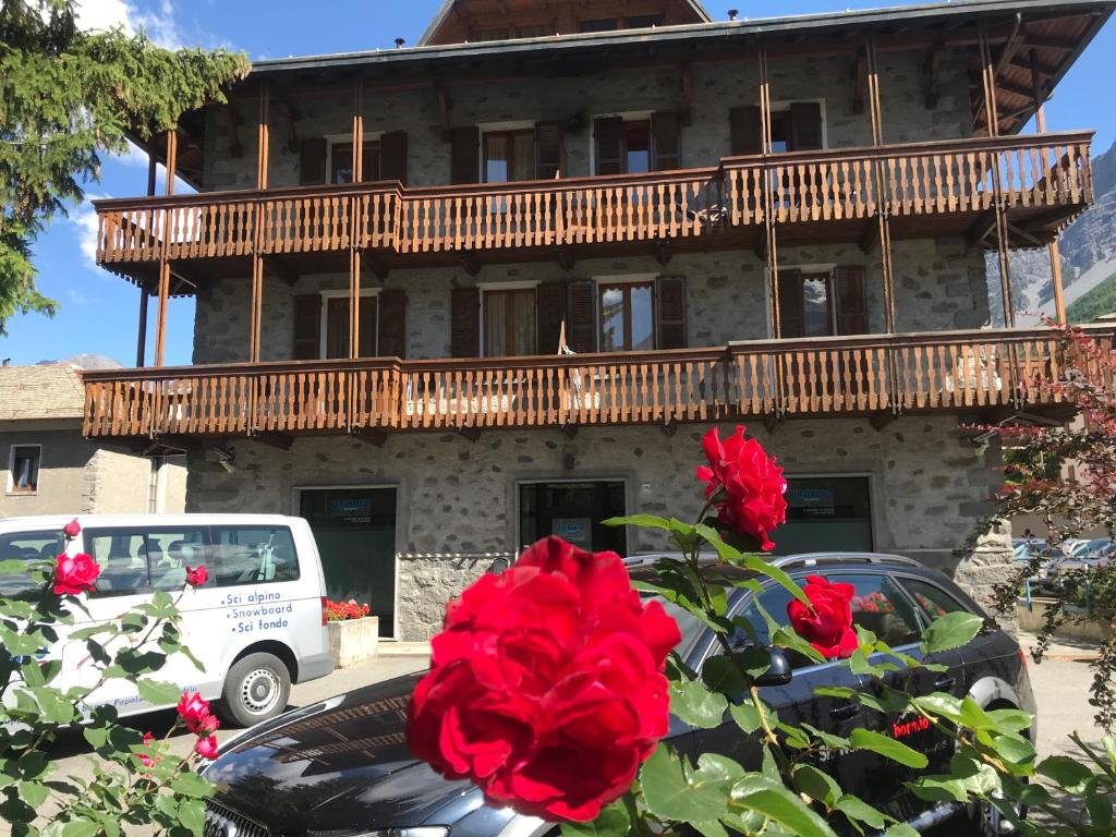 博尔米奥Chalet Felse的前面有红玫瑰的建筑