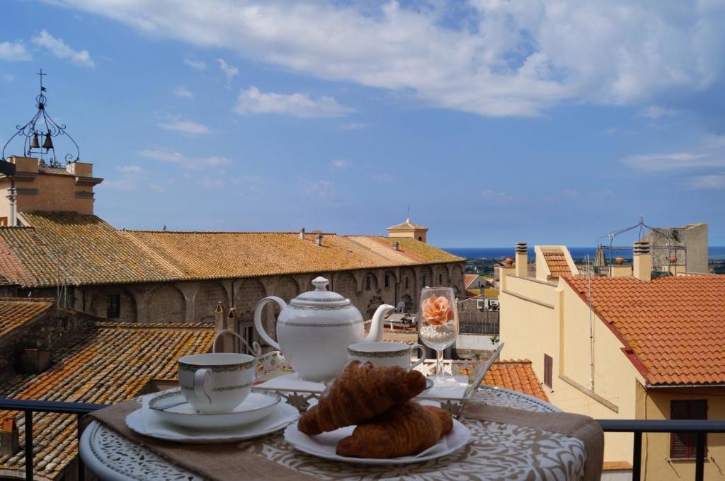 塔尔奎尼亚Le torri di Tarquinia的阳台上的餐桌上放着一盘食物
