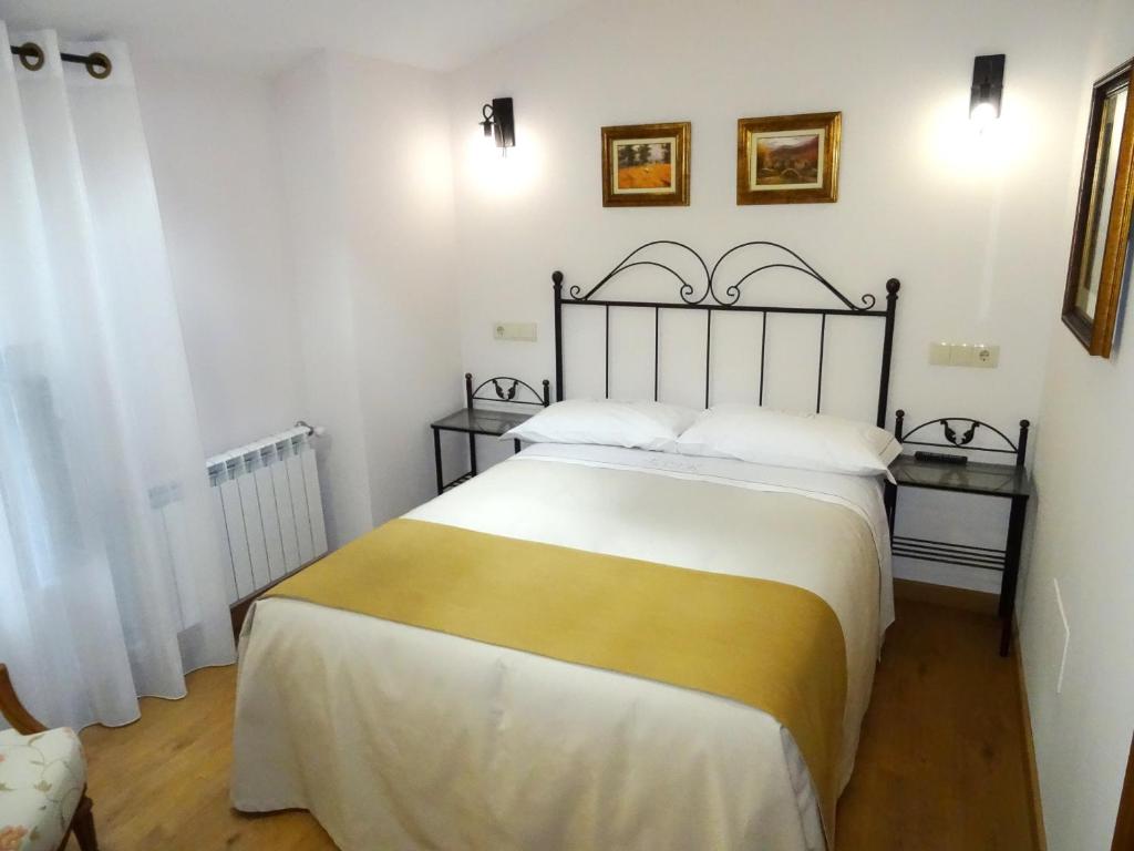 圣地亚哥－德孔波斯特拉LAST 12K的一间卧室配有一张带白色和黄色床单的大床