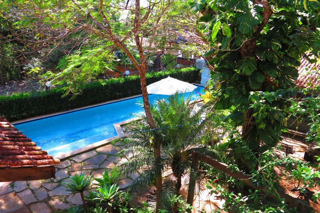 沙帕达-杜斯吉马朗伊斯Sossego Homestay的树荫庭院中的游泳池