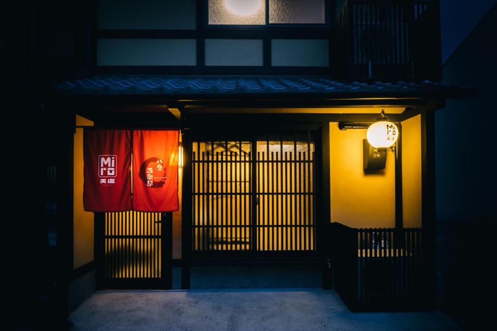 京都Miro Hachijo Genmachi Tei的带有门和旗帜的建筑物入口