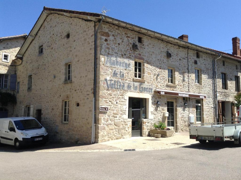 Saint-AuventAuberge de la vallee de la gorre的石头建筑,前面有停车位
