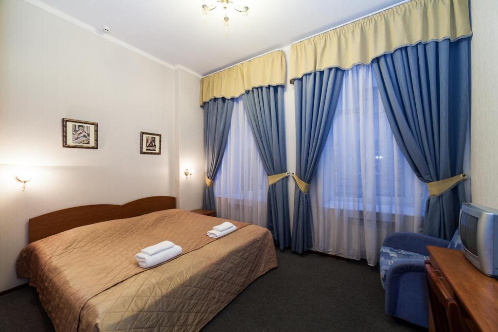 圣彼得堡Амулет на Малой Морской的酒店客房,配有床和电视
