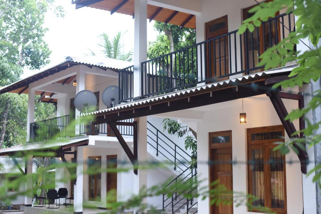 波隆纳鲁沃Kithmi Resort的带阳台和楼梯的房屋