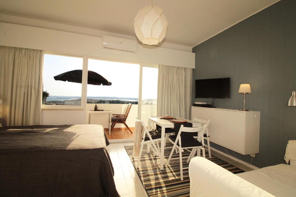 阿尔沃尔Torralta Alvor Beach 601的酒店客房设有一张床铺和一张桌子,享有美景。