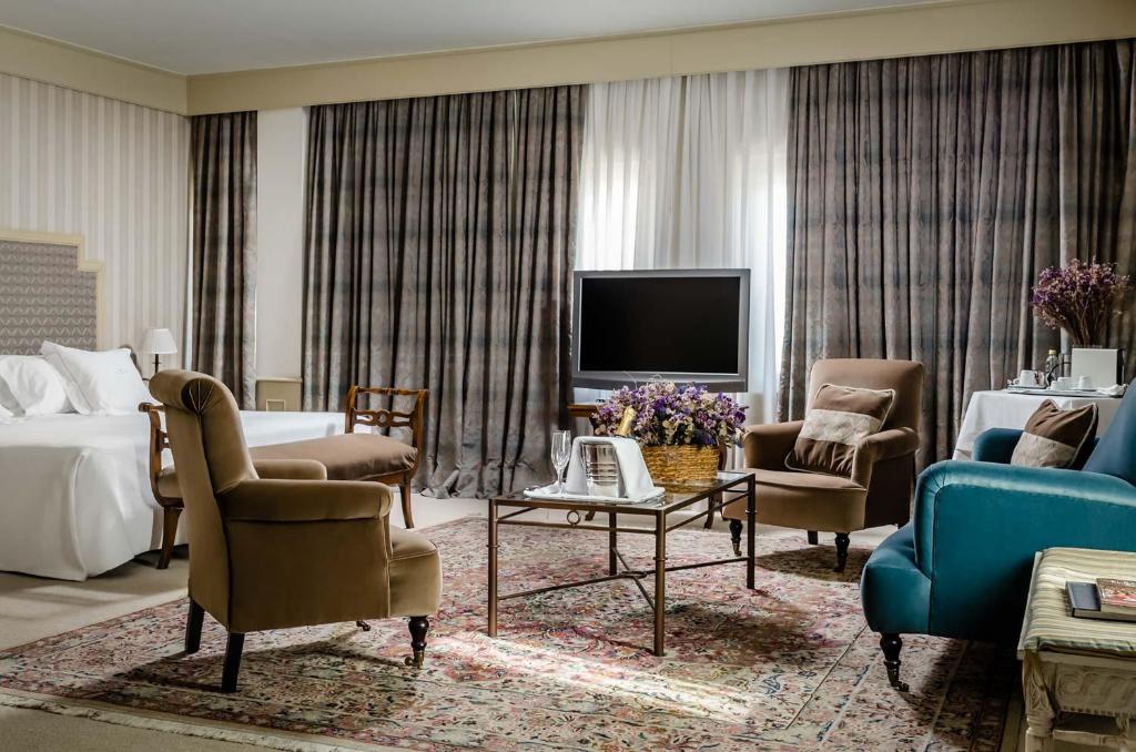 潘普洛纳珍珠大酒店的酒店客房设有床、电视和客厅。