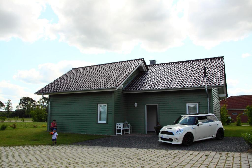 ZarrentinFerienhaus am Schaalsee的一座绿色的小房子,前面有一辆白色的汽车
