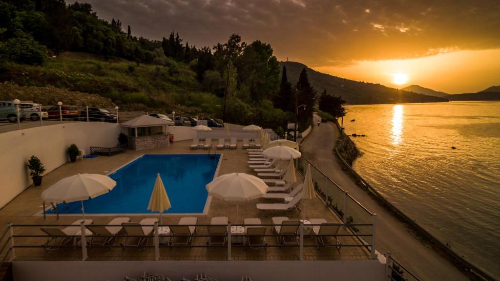 布卡里金色夕阳酒店的游泳池旁设有椅子和遮阳伞