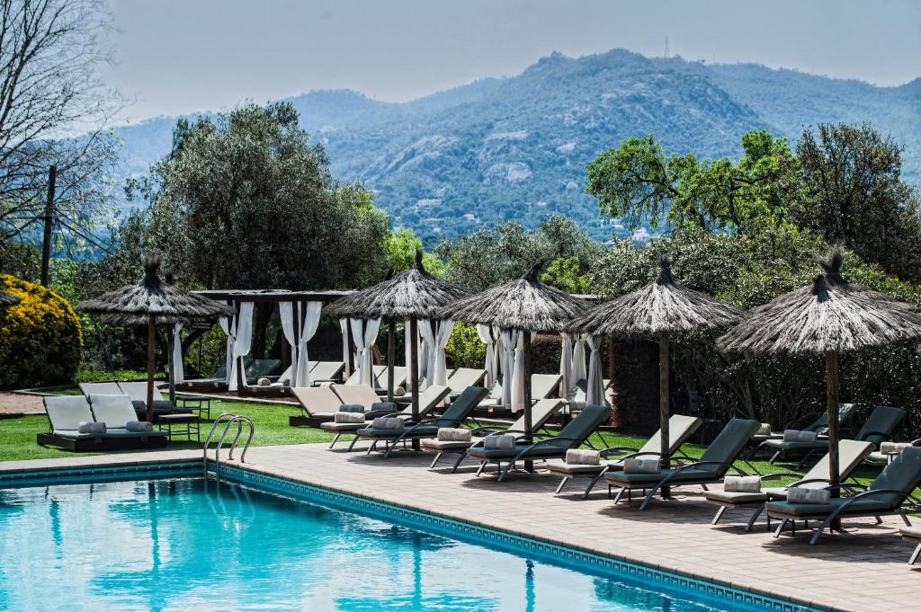 圣塔克里斯蒂纳阿鲁玛斯塔皮欧拉斯酒店的一个带躺椅和遮阳伞的游泳池